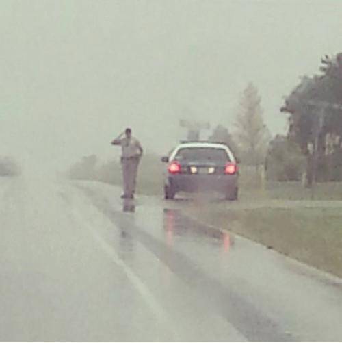 Oklahoma police officer salutes funeral procession in the rain